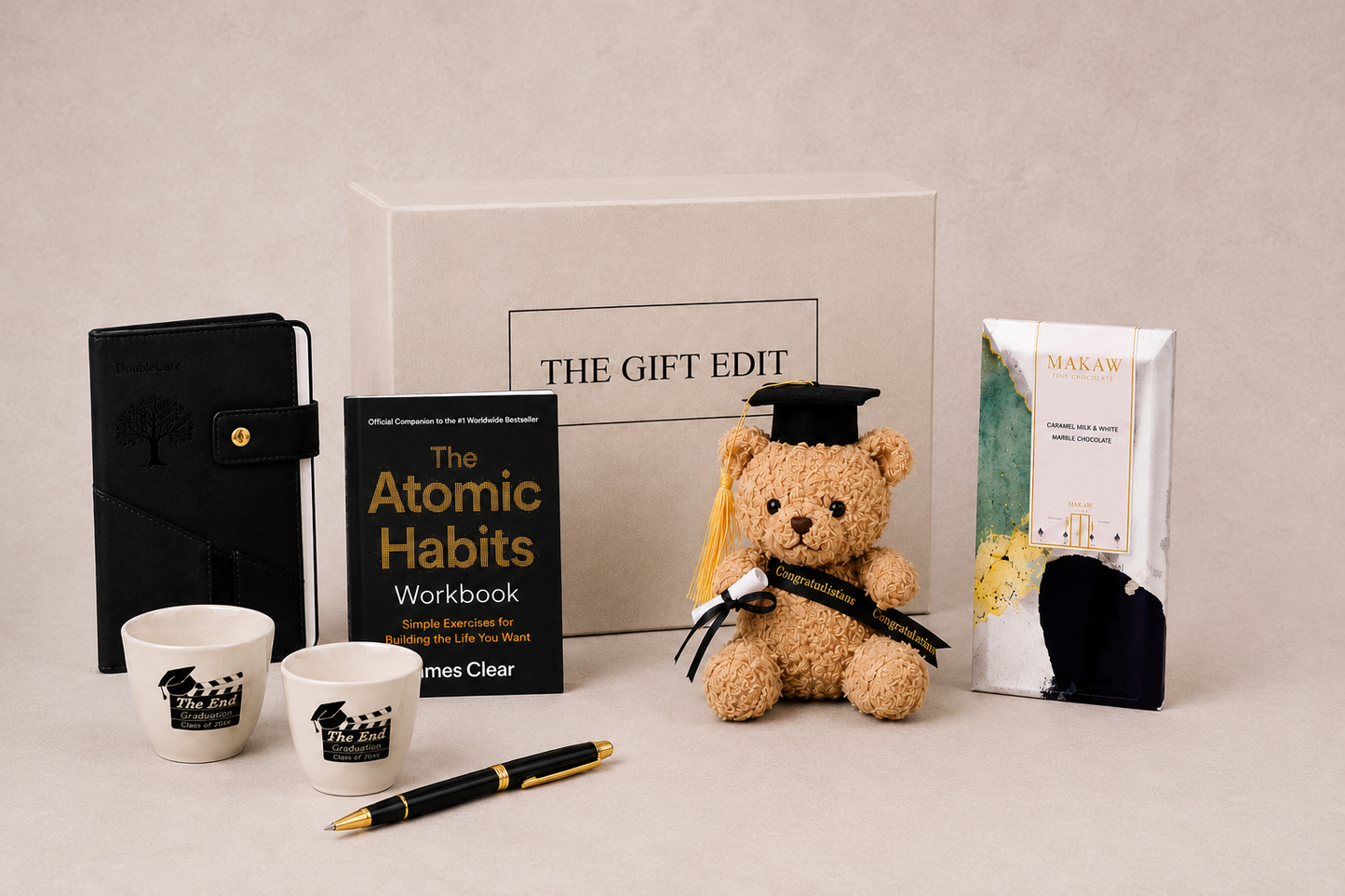 Graduation gifts including chocolate, a book, a notebook and pen and teddy bear for him